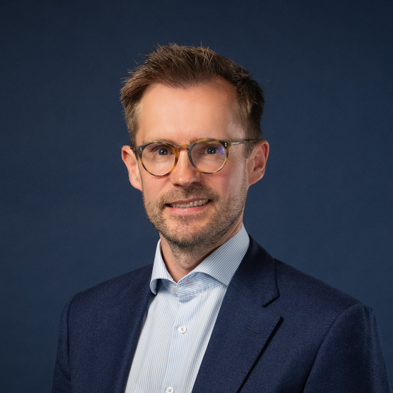 Portrait of Justus Quecke against a dark blue background